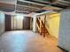 Unfinished basement featuring exposed ceiling, painted floors, and a staircase ready for renovation or storage at 4853 Wentworth Blvd, Indianapolis, IN 46201
