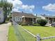 A quaint home with a large front yard framed by a classic chain-link fence at 4853 Wentworth Blvd, Indianapolis, IN 46201