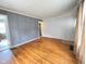 Living room with hardwood floors and decorative wall paneling, leading to other rooms at 4853 Wentworth Blvd, Indianapolis, IN 46201