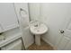 Bathroom featuring a pedestal sink, a large mirror, and modern fixtures, providing a clean and functional space at 5151 Climbing Rose Pl, Indianapolis, IN 46254