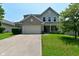 Charming two-story home with a brick and vinyl facade, a two-car garage, and a well-maintained lawn at 5151 Climbing Rose Pl, Indianapolis, IN 46254