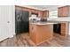 A full view of the kitchen showcasing wooden cabinets, stainless steel appliances, and functional center island at 5151 Climbing Rose Pl, Indianapolis, IN 46254