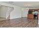 Spacious living room with hardwood floors, staircase, and access to modern kitchen with black appliances at 5151 Climbing Rose Pl, Indianapolis, IN 46254