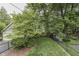 Backyard featuring a well-maintained lawn, mature trees, garden shed and perimeter fencing at 5306 N Kenwood Ave, Indianapolis, IN 46208