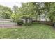 Backyard featuring a well-maintained lawn, mature trees, garden shed and perimeter fencing at 5306 N Kenwood Ave, Indianapolis, IN 46208