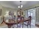 Formal dining room with hardwood floors, elegant furniture, and french doors to sunroom at 5306 N Kenwood Ave, Indianapolis, IN 46208