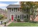 Charming two-story home featuring a red front door, black shutters, and a well-manicured lawn at 5306 N Kenwood Ave, Indianapolis, IN 46208
