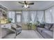 Bright sunroom with a ceiling fan, lots of plants, comfortable seating and multiple windows at 5306 N Kenwood Ave, Indianapolis, IN 46208
