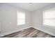 This bedroom features modern flooring, white trim, fresh paint and two windows for ample lighting at 564 S Bosart Ave, Indianapolis, IN 46203