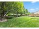 A serene backyard with lush green grass, mature trees, and a privacy fence at 580 Northgate Dr, Greenwood, IN 46143