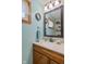 This bathroom features a light blue wall, decorative mirror, and neutral colored countertop at 580 Northgate Dr, Greenwood, IN 46143