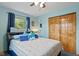 This bedroom features a double bed, two windows, blue curtains, and a sliding closet door at 580 Northgate Dr, Greenwood, IN 46143