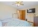 This bedroom features a ceiling fan, closet, and a flat screen television on top of a dresser at 580 Northgate Dr, Greenwood, IN 46143
