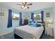 Bright bedroom with two windows, blue curtains, blue accents, ceiling fan, and a double bed at 580 Northgate Dr, Greenwood, IN 46143