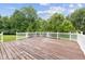 A spacious wooden deck features white railings and a serene view of lush green trees at 5852 Long Ridge Pl, Indianapolis, IN 46221