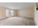 Spacious living room with neutral paint, plush carpet and natural light from a window with sheer curtains at 5852 Long Ridge Pl, Indianapolis, IN 46221
