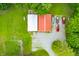 Aerial view of a home with a red metal roof, shed and gravel driveway surrounded by trees on a large, grassy lot at 5858 N West Shore Dr, Morgantown, IN 46160