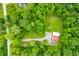Aerial view of a gravel driveway leading to a property with a white and red metal roof, surrounded by trees and grass at 5858 N West Shore Dr, Morgantown, IN 46160