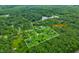 Aerial view of 5.91+/- total acres in Morgantown, Indiana; showcases a house, surrounding trees and marked property lines at 5858 N West Shore Dr, Morgantown, IN 46160