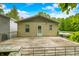 Wide view of back deck and home, features stairs, handrails, gas tank and wooded backdrop with partial blue sky at 5858 N West Shore Dr, Morgantown, IN 46160