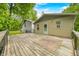 Wide shot of the home's back deck, featuring handrails, stairs and wooded lot with grass at 5858 N West Shore Dr, Morgantown, IN 46160