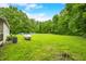 Expansive grassy back yard featuring a few small outbuildings and a tank with a wooded backdrop at 5858 N West Shore Dr, Morgantown, IN 46160