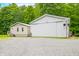 Side exterior view of the vinyl sided home and metal outbuilding, with a graveled parking area at 5858 N West Shore Dr, Morgantown, IN 46160