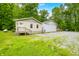 View of house showcasing the front exterior with vinyl siding, an adjacent white outbuilding, and green lawn at 5858 N West Shore Dr, Morgantown, IN 46160
