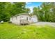Cozy home with a welcoming front porch, nestled among trees, featuring a large metal outbuilding at 5858 N West Shore Dr, Morgantown, IN 46160