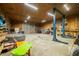 Wood paneled garage with a car lift, a rolling door, and a concrete floor at 5858 N West Shore Dr, Morgantown, IN 46160