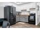 Modern kitchen featuring black appliances, white cabinets, hardwood floors and a rustic backsplash and countertop at 5858 N West Shore Dr, Morgantown, IN 46160