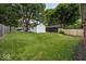 Expansive backyard with lush green lawn and detached garages at 6005 Winthrop Ave, Indianapolis, IN 46220