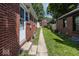 Long shot of the walkway and yard area, lined with grass and trees at 6005 Winthrop Ave, Indianapolis, IN 46220