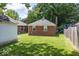 Backyard featuring a well-maintained lawn and brick detached garage at 6005 Winthrop Ave, Indianapolis, IN 46220