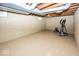 This basement features painted floors, painted block walls, and an exercise machine at 6005 Winthrop Ave, Indianapolis, IN 46220