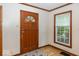 Welcoming entryway featuring a wooden door, hardwood floors, and natural light from a window at 6005 Winthrop Ave, Indianapolis, IN 46220