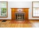 Elegant fireplace with a decorative wooden mantel and tiled hearth, set between two windows at 6005 Winthrop Ave, Indianapolis, IN 46220