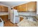 Functional kitchen featuring granite countertops and oak cabinetry at 6005 Winthrop Ave, Indianapolis, IN 46220