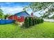 The backyard features a row of trees near a house with a blue fence and lush green grass at 602 Pioneer Dr, Indianapolis, IN 46217