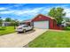 View of a red brick home with attached garage, driveway, and lush green lawn under a bright blue sky at 602 Pioneer Dr, Indianapolis, IN 46217
