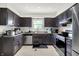 Bright kitchen featuring dark cabinets, stainless steel appliances, tiled floors, and a window above the sink at 602 Pioneer Dr, Indianapolis, IN 46217