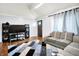 Living room with hardwood floors, gray sofa, large speakers, and vaulted ceiling with contemporary decor at 602 Pioneer Dr, Indianapolis, IN 46217