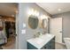 Modern bathroom features double vanity with marble countertop, gold fixtures, round mirrors, and walk-in closet at 615 E Stop 11 Rd, Indianapolis, IN 46227