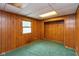 Cozy bedroom with wood-paneled walls and a bright window, offering a simple retreat at 615 E Stop 11 Rd, Indianapolis, IN 46227