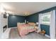 Inviting bedroom with blue walls, modern lighting, and a view to the outdoors at 615 E Stop 11 Rd, Indianapolis, IN 46227
