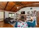 Cozy living room with exposed-beam ceiling, brick fireplace, custom built-ins and view of the front yard at 615 E Stop 11 Rd, Indianapolis, IN 46227