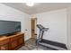 Spacious room with a treadmill, wood-look floors, a TV and is next to an open doorway at 615 E Stop 11 Rd, Indianapolis, IN 46227