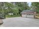 Spacious concrete driveway leading to a two-door garage nestled amongst mature trees at 625 E 57Th St, Indianapolis, IN 46220