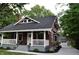 Beautiful home featuring a white-railed porch, manicured landscaping and a detached garage at 625 E 57Th St, Indianapolis, IN 46220