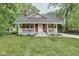 Quaint home with a welcoming front porch, lush lawn, and a picturesque, tree-lined backdrop at 625 E 57Th St, Indianapolis, IN 46220